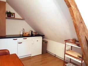 a kitchen with a white cabinet in a attic at Studio Hugo in Nijmegen
