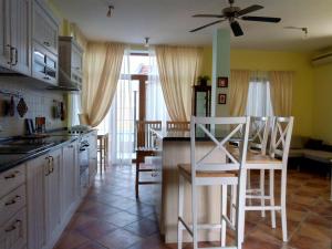 a kitchen with white cabinets and a table and chairs at Villa California in Tivat