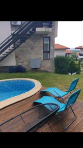 a blue chair sitting next to a swimming pool at Bay View Villas - Summer house Gerovi in Kosharitsa