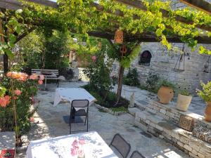 a patio with a table and chairs under a pergola at Konaku Guest house in Gjirokastër