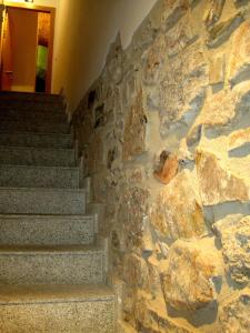 a stone wall with stairs in a building with rocks at Apartamentos Turísticos ENCANTO in Cáceres
