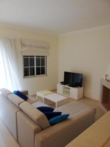 - un salon avec un canapé et une télévision dans l'établissement Villa V2 C, à Albufeira