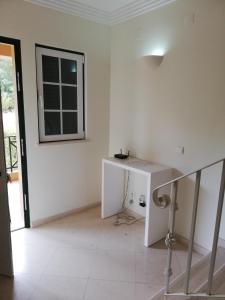 um quarto branco com uma mesa e uma janela em Villa V2 C em Albufeira