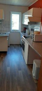 a kitchen with a counter top and a kitchen with a window at Ferienwohnung Aue in Bad Lauterberg