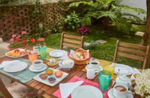 una mesa de madera con alimentos para el desayuno y bebidas. en Casadacidade, en Ponta Delgada