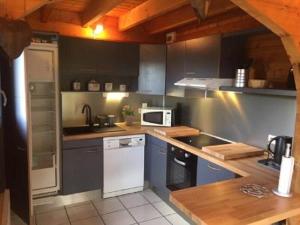 una cocina con armarios azules y electrodomésticos blancos en Chalet Le Roncing, en Gérardmer