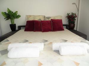 - un lit avec 2 oreillers rouges dans l'établissement Le Cap Californie, à Nice