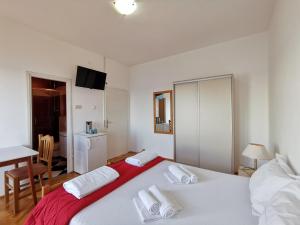 um quarto com uma grande cama branca e uma mesa em Rooms Ante em Tribanj-Krušćica