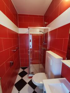 y baño rojo con aseo y ducha. en Rooms Ante en Tribanj-Krušćica