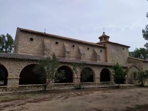 un grande edificio in mattoni con una torre in cima di casa rural cal antoniet del matarraña a Matarraña