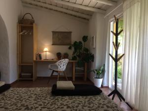 a bedroom with a bed and a desk and a chair at Quinta da Fornalha - Santuario Agroecologico in Castro Marim