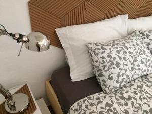 a bed with a black and white pillow and a lamp at Quinta da Fornalha - Santuario Agroecologico in Castro Marim