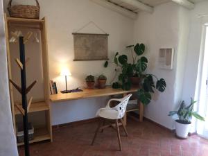 a room with a desk with a chair and plants at Quinta da Fornalha - Santuario Agroecologico in Castro Marim