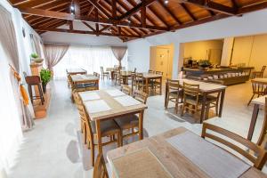 ein Restaurant mit Holztischen und -stühlen und einer Theke in der Unterkunft LENA ROSA Premium Hotel in Pomerode