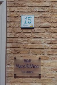 a sign on the side of a brick wall at Mare DiVino in Porto Recanati