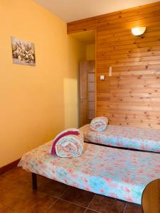 a bedroom with two beds and a wooden wall at Гостевой дом "Дача Салтов" in Staryy Saltiv