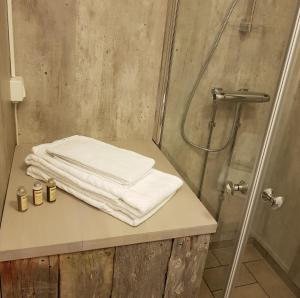 y baño con ducha y toallas blancas en la encimera. en Yggdrasil Farmhotel Retreat, Spa & Yoga en Straumsbukta