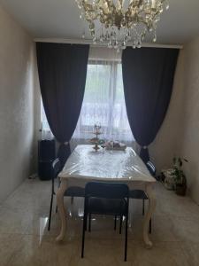 uma mesa de jantar com 2 cadeiras e um lustre em ARKADIYA HOUSE em Odessa