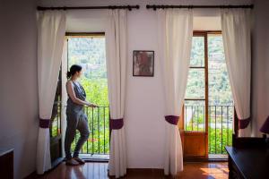 a woman standing at a window looking out at Hostal Villa Verde-Adults Only in Deia +107 photos