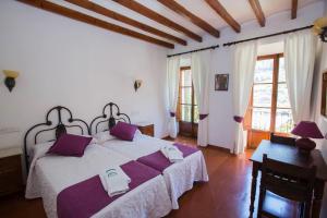 a bedroom with a large bed with purple pillows at Hostal Villa Verde-Adults Only in Deia