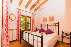 a bedroom with a bed with purple pillows on it at Hostal Villa Verde-Adults Only in Deia