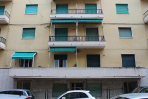 un immeuble d'appartements avec balcon et voitures garées devant dans l'établissement Appartamento Pierina - (009001-LT-0668), à Alassio