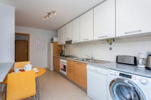 a kitchen with white cabinets and a dishwasher at Cabanas Beach Penthouse in Cabanas de Tavira
