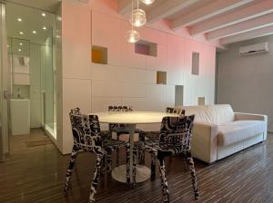 a dining room with a table and chairs and a couch at Welcome Traveller ATMOSPHERE APARTMENT in Bardolino