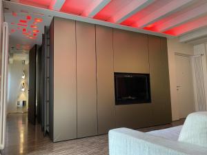 a room with a bed and a tv on a wall at Welcome Traveller ATMOSPHERE APARTMENT in Bardolino +7 photos