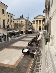 an empty courtyard with tables and benches and buildings at Welcome Traveller ATMOSPHERE APARTMENT in Bardolino