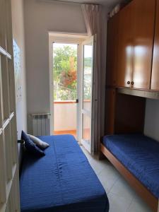 サンタ・マリア・ディ・カステッラバーテにあるCasa Polverinoのベッドルーム1室(ベッド2台付)、スライド式ガラスドアが備わります。