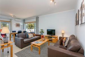 a living room with two couches and a television at Cabanas Beach Penthouse in Cabanas de Tavira