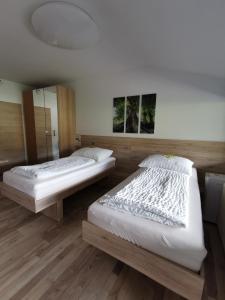 2 Betten in einem Zimmer mit Holzböden in der Unterkunft Appartement mit Doppelbett oder 2 Einzelbetten in Bad Aussee