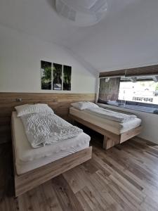 2 Betten in einem Zimmer mit Holzböden in der Unterkunft Appartement mit Doppelbett oder 2 Einzelbetten in Bad Aussee