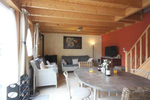 ein Wohnzimmer mit einem Tisch und einem Sofa in der Unterkunft Journal aux Lacs-5pers in Froidchapelle