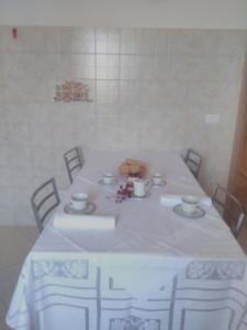 un tavolo con tovaglia bianca, tazze e piattini di La casetta a Ortona