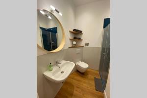 uma casa de banho com um lavatório, um espelho e um WC. em Myhappyplace two in the middle of Berlin em Berlim