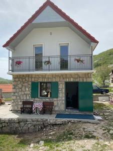 a house with a balcony on top of it at Guest House Markovic Lovcen in Cetinje