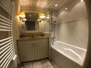 a bathroom with a sink and a tub and a mirror at Logement avec terrasse sur lac, tout confort, dans résidence avec PLAGE et PONTON PRIVEE in Duingt