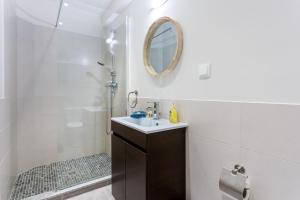 a bathroom with a sink and a shower with a mirror at Mariners (2) - Bright and stylish apartment - walk to the beach in Luz +22 photos