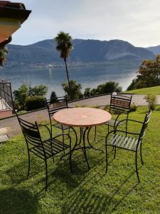 una mesa y sillas con vistas al agua en Villetta Primavera Suna Vista lago CIR10307200215 en Verbania
