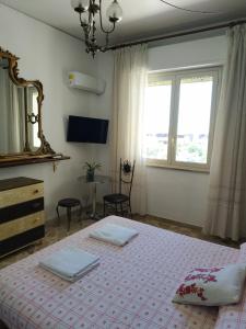 1 dormitorio con cama, espejo y mesa en Tilde B&B en Cefalù
