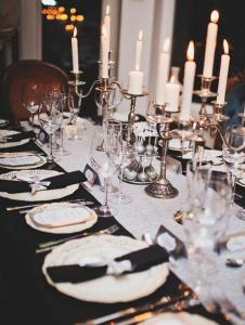 une table avec des bougies, des assiettes et des verres dans l'établissement Ööbikuoru Villa, à Rõuge