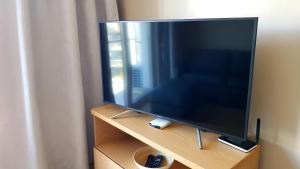 TV de pantalla plana grande con soporte de madera en Apartament Wrocław Marina nad Odrą 29 en Breslavia