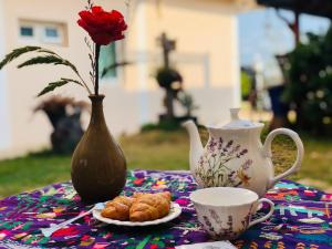 a table with a vase and a plate of croissants and a tea at PrivateRayong in Rayong