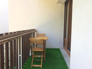 a desk and two chairs sitting on a balcony at Appartement d'une chambre avec balcon amenage et wifi a Briancon in Briançon