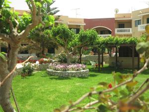 un jardín con árboles y flores frente a un edificio en Gramvoussa Bay en Kíssamos