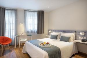 una camera d'albergo con un letto su cui è appoggiato un vassoio di frutta di Hotel das Salinas by Alboi Group ad Aveiro