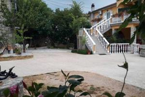 a large courtyard with a house and a staircase at Apartments Nella in Sveti Anton