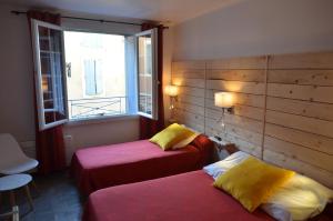 ein Hotelzimmer mit 2 Betten und einem Fenster in der Unterkunft Hôtel Restaurant Panoramique César in Bonnieux